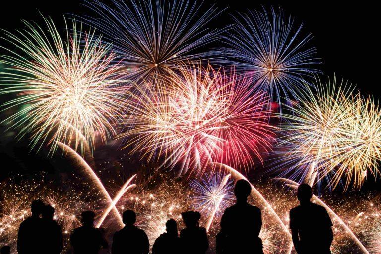 7 Idee Per Preparare La Tua Casa Vacanza Al Capodanno: gruppo di persone guarda i fuochi d'artificio per l'ultimo dell'anno