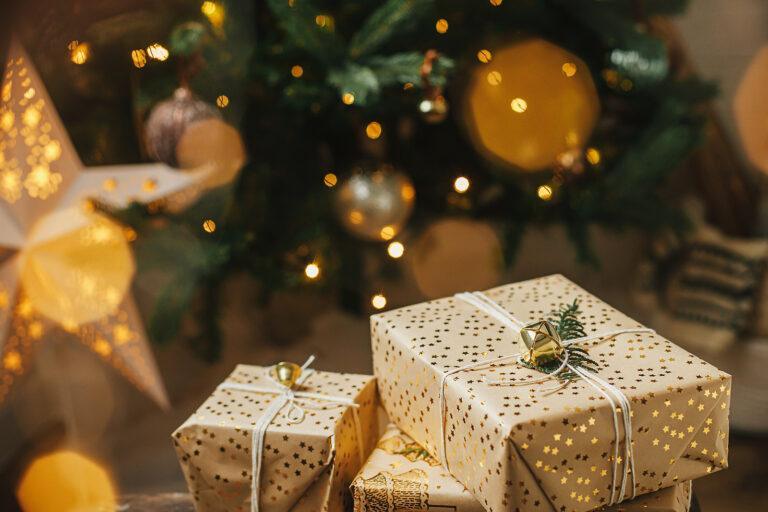 pacchetti regalo con carta dorata sotto l'albero in una casa vacanze