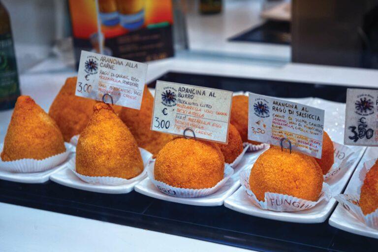 un vassoio con diversi tipi di arancini (alla carne, al burro, al ragu di salsiccia) perfetti per una degustazione culinaria